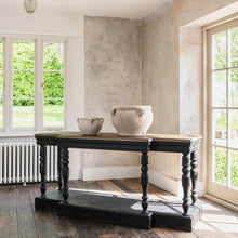 Load image into Gallery viewer, Stunning bleached oak topped console table. The detailing on this console makes it a firm favourite with the One World team. Not only does the unusual shape make it striking but add to that the distressed black finish and the textures wooden top and you have a real conversation piece. Just add lamps, a couple of beautiful mirrors and you are done.
