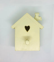 Load image into Gallery viewer, A wooden coat peg painted in cream color, shaped like a bird house with a heart cutout and a small bird silhouette on the top.
