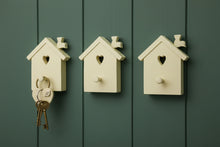 Load image into Gallery viewer, A wooden coat peg painted in cream color, shaped like a bird house with a heart cutout and a small bird silhouette on the top.